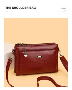 Detailed view of the wine red PU leather multi-layer shoulder bag with practical zippered pockets.