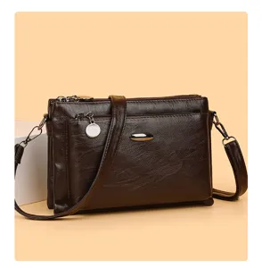 Close-up detail view of the brown PU leather multi-layer crossbody bag zipper and texture.