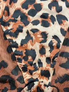 Detailed macro view showing leopard print pattern and brown mesh texture of bodysuit