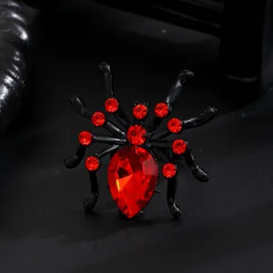 Close-up detail of gothic punk spider ring featuring vibrant red rhinestones and black metal finish
