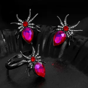 Close-up of gothic spider rings featuring vibrant red and magenta faceted crystals