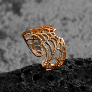Close-up view of the detailed gold-plated spiderweb hollow-out ring for gothic styling.