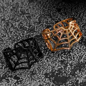 Detailed macro view of gothic punk spider web rings in black and rose gold metallic finishes.