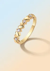 Detailed view of a golden S925 silver ring with heart shapes and moissanite stones