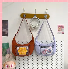 Vista detallada de bolsos ita de lona en forma de medialuna con ventana transparente