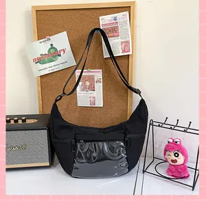 Primer plano de bolso ita de lona negra con bolsillo frontal transparente