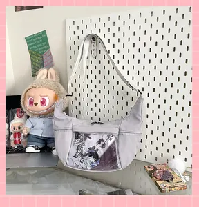 Detalle de bolso ita gris en forma de medialuna con una ventana transparente.