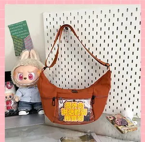 Detalle del bolso ita de lona marrón en forma de luna con ventana de PVC.