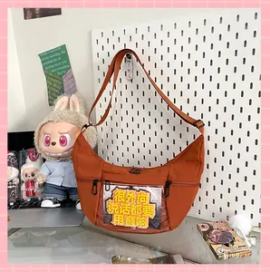 Bolso ita naranja en forma de medialuna con ventana transparente para mostrar insignias