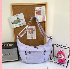 Bolso de lona lavanda en forma de media luna con ventana de PVC en ambiente acogedor.