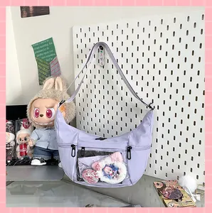 Vista detallada de un bolso Ita en forma de luna creciente lila con ventana transparente