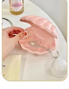 Pink ceramic seashell jewelry box detail showing ring storage and glossy surface finish.