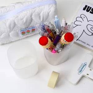 Round transparent frosted pen holder detail showcasing desktop stationery organization.