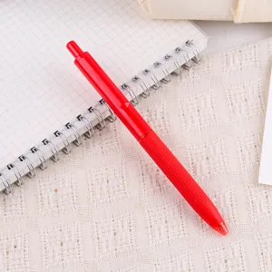 Nahaufnahme roter Gelstift mit weichem Griff Detail auf Notizbuch und Spitzendecke.