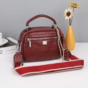 Dunkelrote Vintage Leder Boston Handtasche mit breitem Schulterriemen und mehreren Fächern.