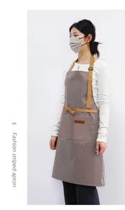Tablier rayé marron et blanc avec lanières en cuir et poche pour cuisine et cuisson.