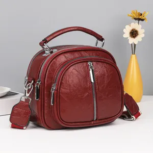 Elegante dunkelrote weiche Leder Damen Umhängetasche mit mehreren Reißverschlüssen.
