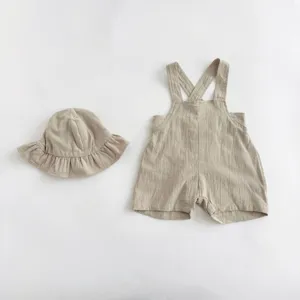 Detailed shot of the baby cotton linen solid strap romper and matching sun hat set style.