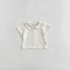 Detailed view of white baby infant short sleeve t-shirt with cute peter pan collar design.