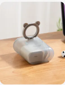 Détail boîte de rangement de câbles grise, support téléphone oreille d'ours.