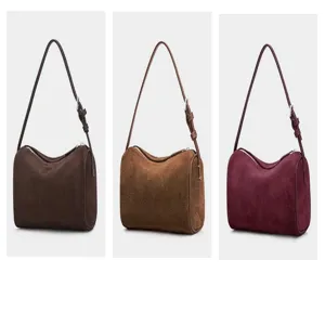 Stylish suede cylindrical shoulder bag available in dark brown, camel, and burgundy variants.