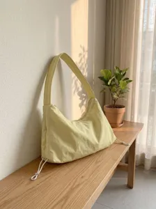 Detail view of the light yellow nylon hobo shoulder bag showing its smooth texture.