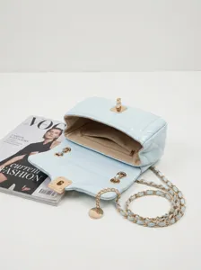 Vue détaillée du sac à bandoulière matelassé bleu clair avec chaîne dorée et fermoir chic.