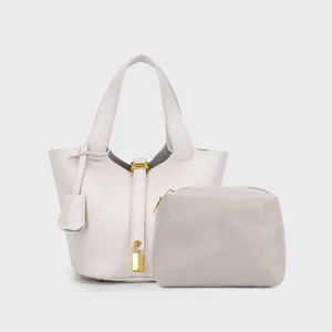 Grey PU leather bucket bag detail view with chevron pouch, golden lock and pebble texture.