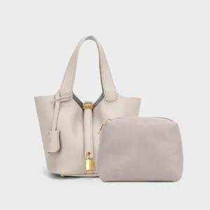 Minimalist PU leather bucket handbag and matching pouch set with lock detail, elegant daily use.