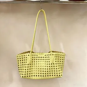 Yellow woven leather tote bag detailed view, elegant cutout geometric shoulder handbag.