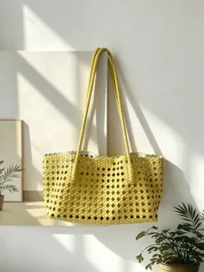 Close-up detail view of the elegant yellow woven shoulder tote bag in a minimalist scene.