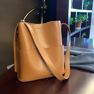 Detailed view of the stylish brown leather bucket bag, featuring structured design and ample space.