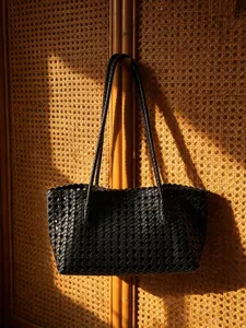 Detail shot of a stylish black woven leather shoulder tote bag for women daily casual commute.