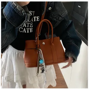 Brown leather tote bag for women, stylish top handle shoulder bag with charm decoration daily.