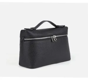 Detail view of the black textured mini lunch box handbag, showcasing fine zipper and top handle.