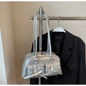 Sac à épaule métallique argenté avec double nœud et poches avant, design tendance style ballet.