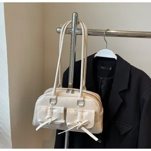 Vue détaillée d'un sac à main blanc en cuir avec poches à nœuds et fermetures éclair.