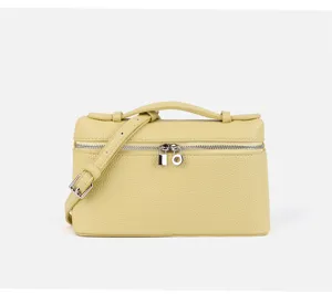 Close-up view of a chic yellow mini vanity box bag featuring top handle and adjustable strap.