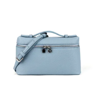 Close-up detail of the structured blue leather vanity box bag showing zipper and hardware.