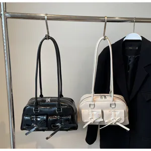 Vue détaillée du sac à bandoulière élégant avec doubles anses et jolies poches nœuds.