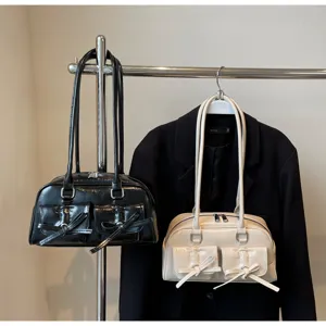 Vue détaillée du sac épaule en cuir verni avec nœud, élégant sac style ballet-core chic.