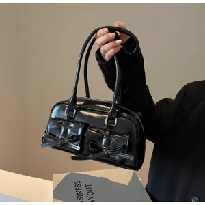 Sac portepaule en cuir verni noir avec noeuds chics et double poche pour un style quotidien.