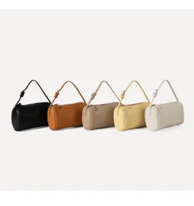 Minimalist cylindrical leather shoulder bag for women, featuring soft lychee pattern texture.