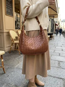 Detailed view of a stylish retro woven shoulder bag, casual underarm design in brown leather.