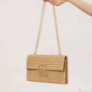 Woven straw shoulder bag with gold chain strap and metal turn lock clasp for women summer holiday.