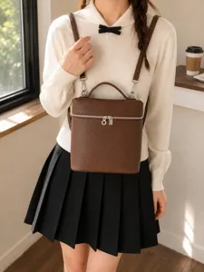 Vue détaillée du sac à dos marron en cuir, mettant en valeur les fermetures métalliques.