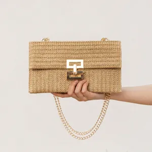 Detailed view of women's straw woven shoulder bag with chic chain strap and gold twist lock.