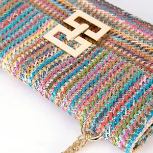 Colorful woven straw shoulder bag detail, featuring metallic chain and golden lock.