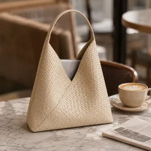 Close-up view of beige woven leather shoulder bag showing exquisite craftsmanship and texture.