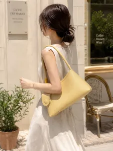 Vue détaillée du sac porté épaule hobo jaune minimaliste en extérieur pour le quotidien.